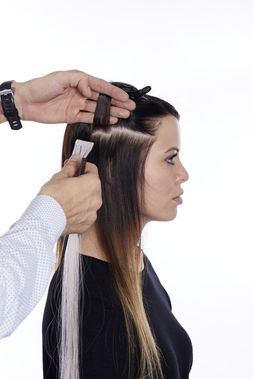 Lisa GL Tapes02: Das GL Tape wird circa 0,5 Zentimeter von der Kopfhaut unter der zuvor abgeteilten Haarpartie positioniert. (&copy; &copy; Great Lengths)