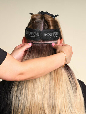 Y0UYOU Tressen, Step 4: Um die Breite anzupassen, die<br />
ungekürzte Tresse oberhalb der<br />
Mikroringe anhalten: Auf beiden<br />
Seiten sollte die Tresse so enden,<br />
dass sie jeweils etwas über den<br />
äußeren Mikroring übersteht,<br />
aber nicht über das zur<br />
Befestigung abgeteilte Rechteck<br />
hinausragt. Das passende Stück<br />
zuschneiden. (&copy; © Great Lengths / YOUYOU)